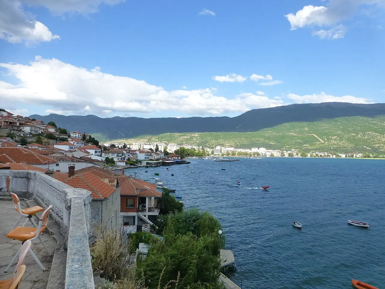 Lake Ohrid seen from a stone terrace above the old town, red-tiled roofs and mountains across the water